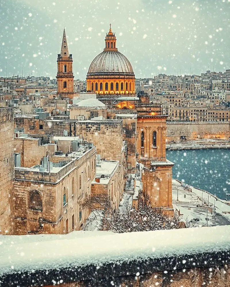 Snow falling over the domes of the city