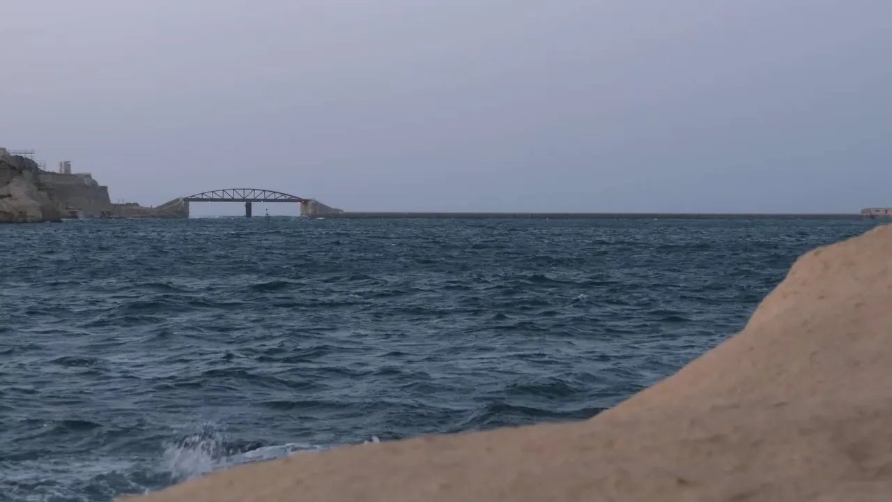 The Grand Harbour breakwater at blue hour, a frame from The Unsinkables